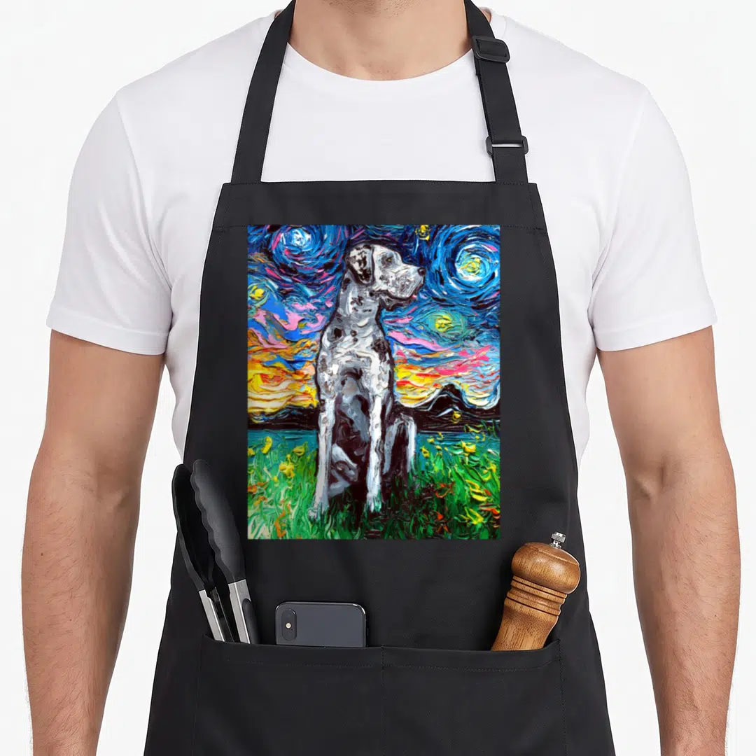Merle dog apron - Seated merle dog on green grass under swirling blue yellow and black starry night sky art — shown on a black cotton canvas apron against a white background