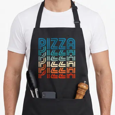 Carb pizza apron - Stacked PIZZA text in blue teal cream orange red gradient typography — shown on a black cotton canvas apron against a white background