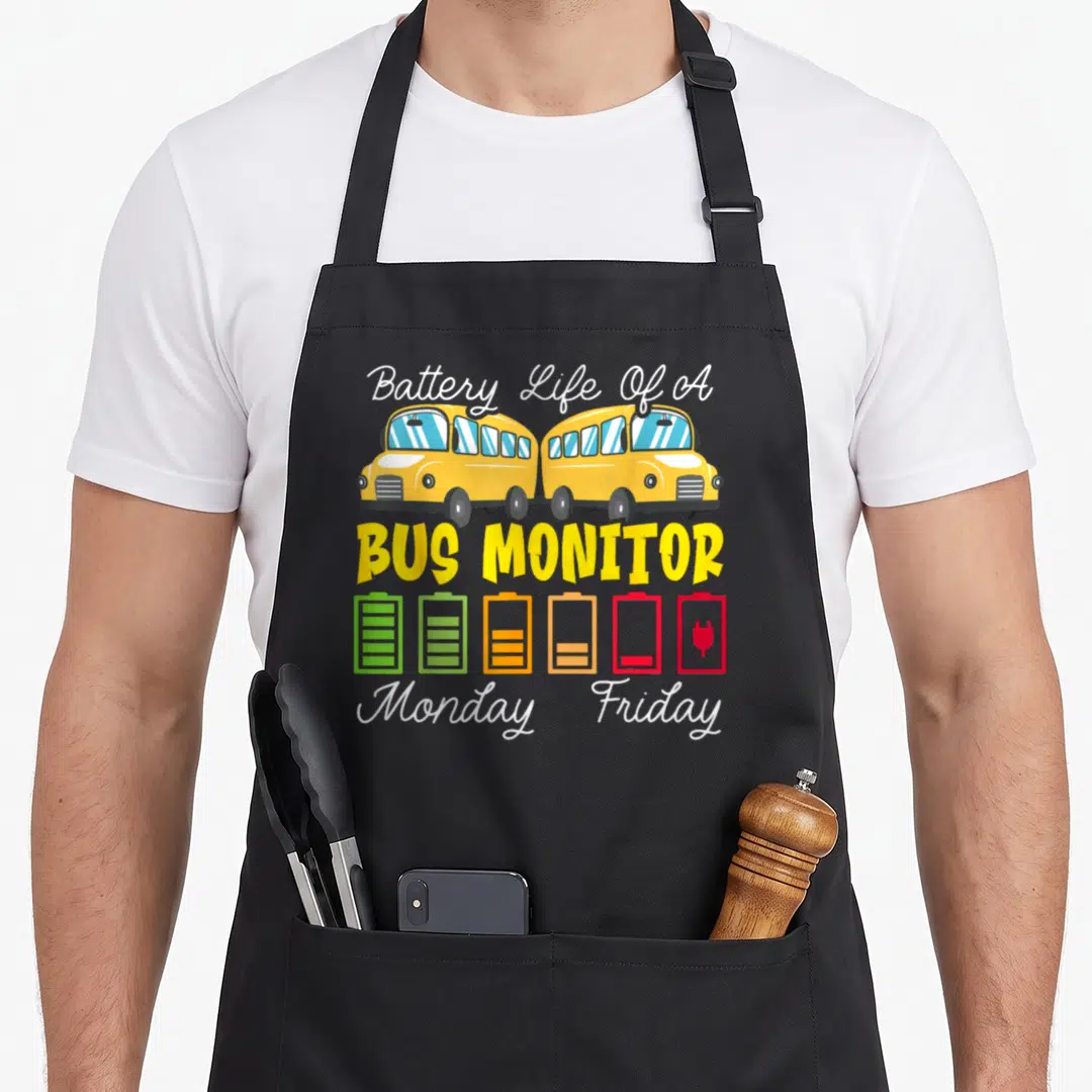 Monitor school bus apron - Two yellow buses above a battery icon draining from green to red plug with text — shown on a black cotton canvas apron against a white background