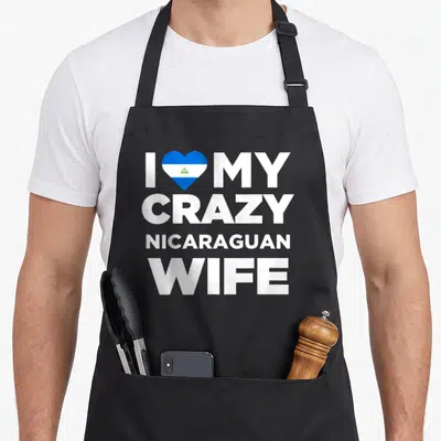 Nicaragua wife apron - White stacked text I MY CRAZY NICARAGUAN WIFE with blue white flag heart replacing love — shown on a black cotton canvas apron against a white background