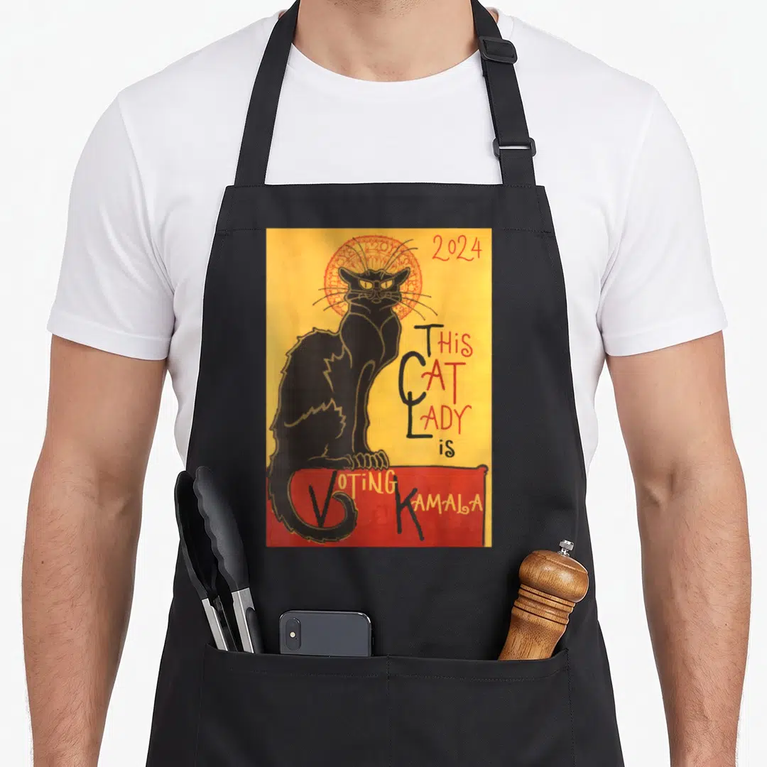 Chat cat lady apron - Black cat with red halo on yellow background holding red voting banner with 2024 text — shown on a black cotton canvas apron against a white background