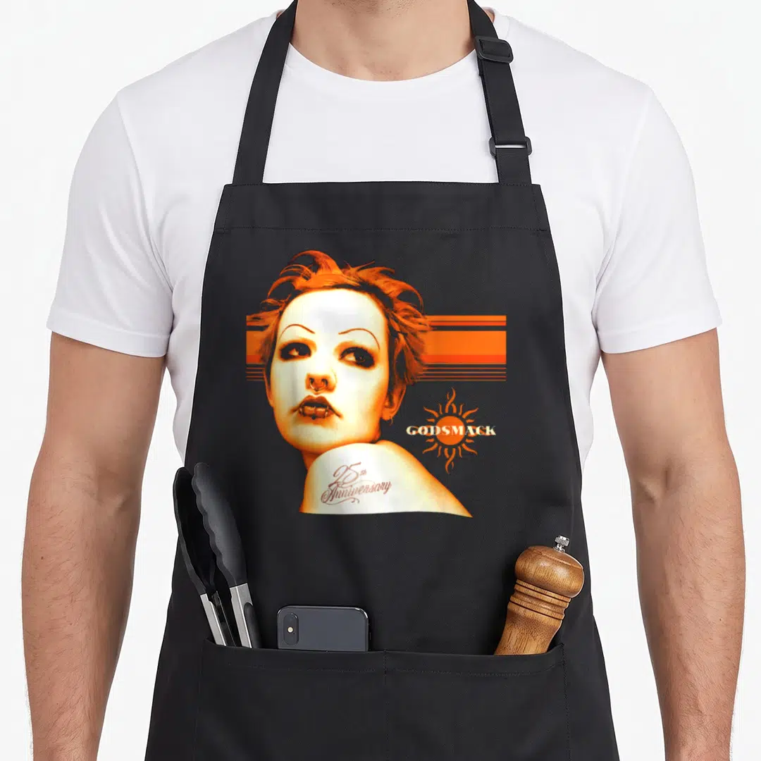 Godsmack anniversary apron - Woman portrait with orange stripes, sun symbol, and 25th Anniversary text — shown on a black cotton canvas apron against a white background