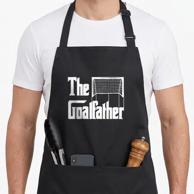 Goalfather goalkeeper apron - White typography reading The Goalfather next to a soccer goal outline — shown on a black cotton canvas apron against a white background