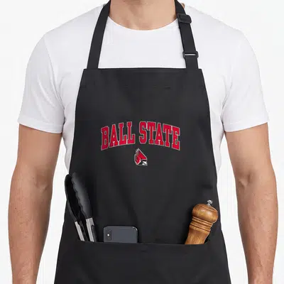 Ball cardinal apron - Arched red BALL STATE text above a cardinal head logo in red white and black — shown on a black cotton canvas apron against a white background