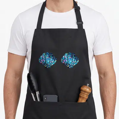 Shell birthday apron - Two glittery seashells in blue, purple, and cyan side-by-side — shown on a black cotton canvas apron against a white background