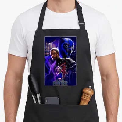 Movie wakanda apron - Black Panther movie poster print with T'Challa, mask, and city in blue purple black gold — shown on a black cotton canvas apron against a white background