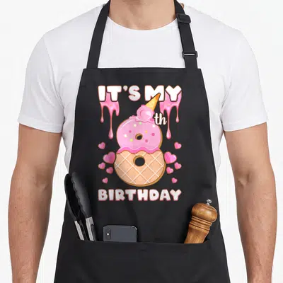 Birthday 8th ice cream apron - Pink number 8 shaped like a frosted ice cream cone with hearts and birthday text — shown on a black cotton canvas apron against a white background
