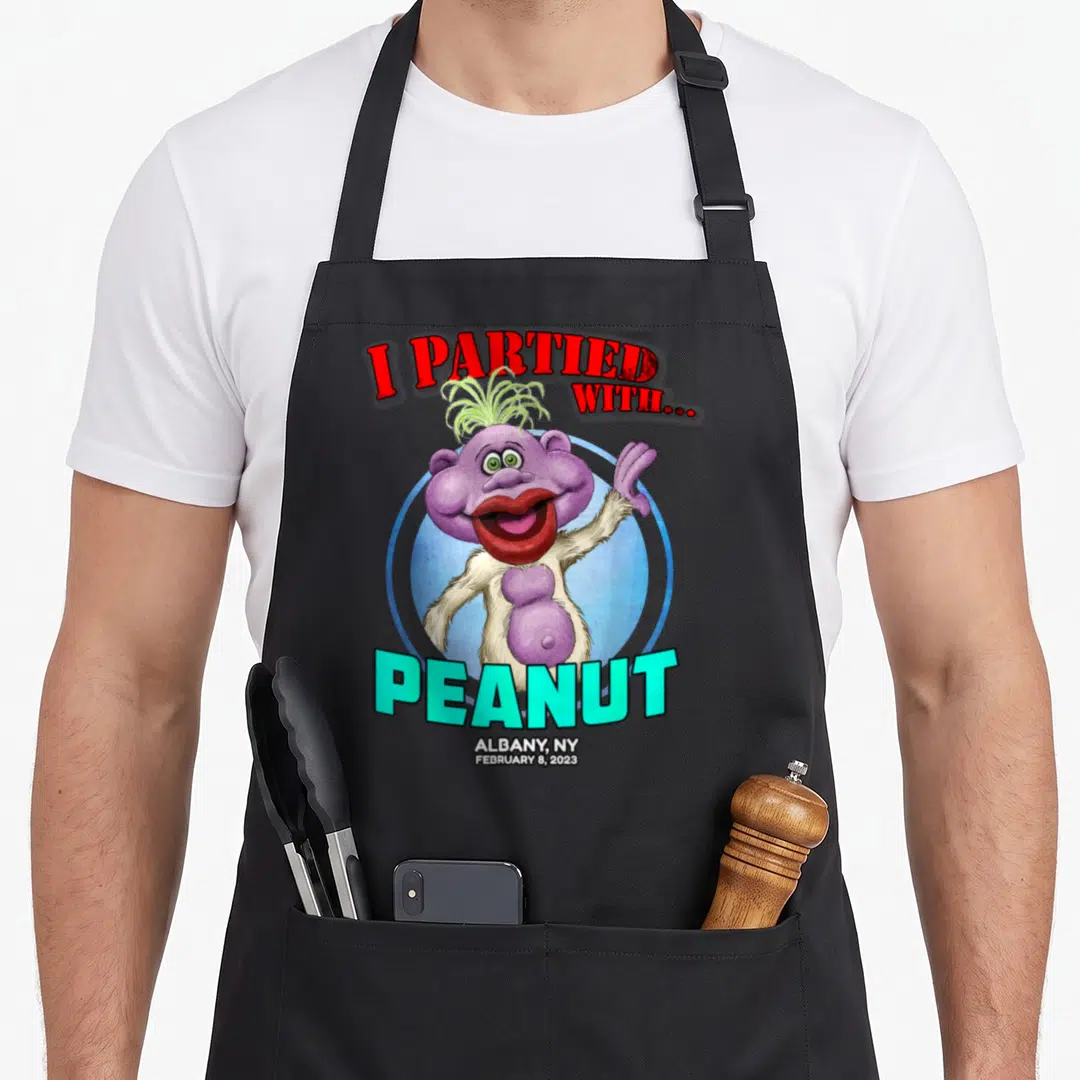 Peanut albany apron - Purple monster with I Partied With Peanut text and Albany NY date — shown on a black cotton canvas apron against a white background