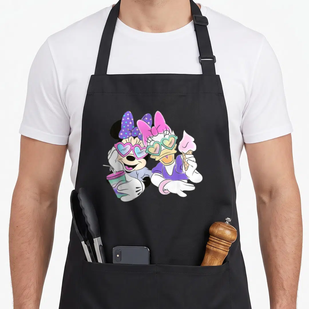 Funny daisy apron - Minnie and Daisy in heart sunglasses holding drink and ice cream, pink purple blue white cartoon — shown on a black cotton canvas apron against a white background