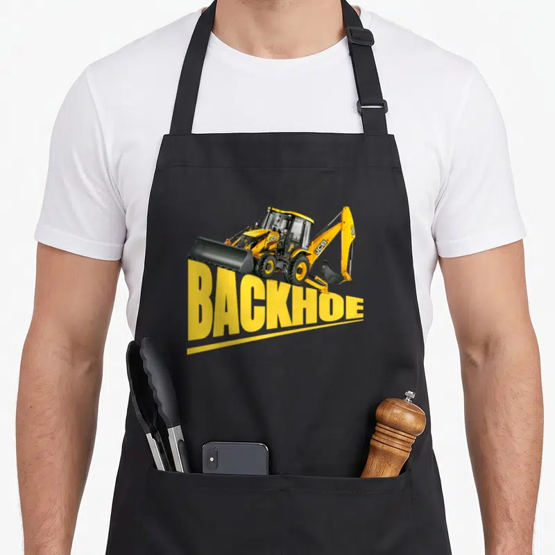 Backhoe heavy apron - Yellow backhoe loader graphic sitting atop large yellow BACKHOE text on black fabric — shown on a black cotton canvas apron against a white background
