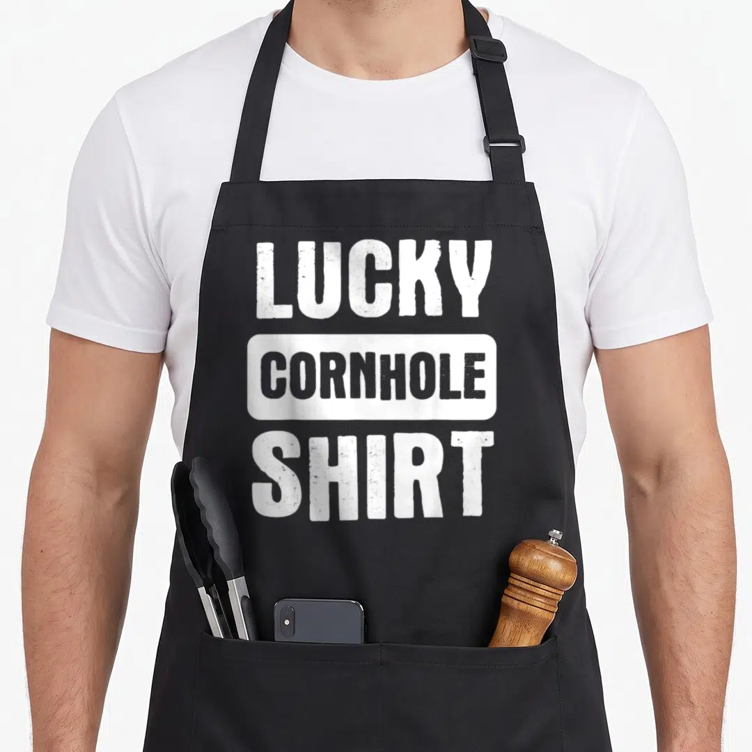 Lucky cornhole bags and aprons - Stacked white and grey text reading LUCKY CORNHOLE SHIRT — shown on a black cotton canvas apron against a white background