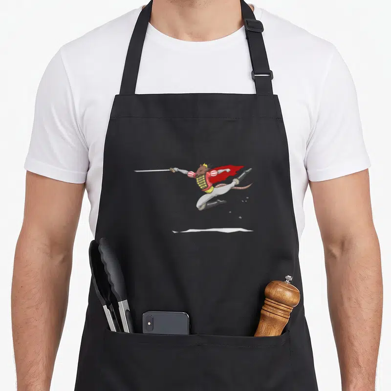 Mouse king apron - Cartoon brown rat in red uniform leaping with silver sword and yellow crown — shown on a black cotton canvas apron against a white background