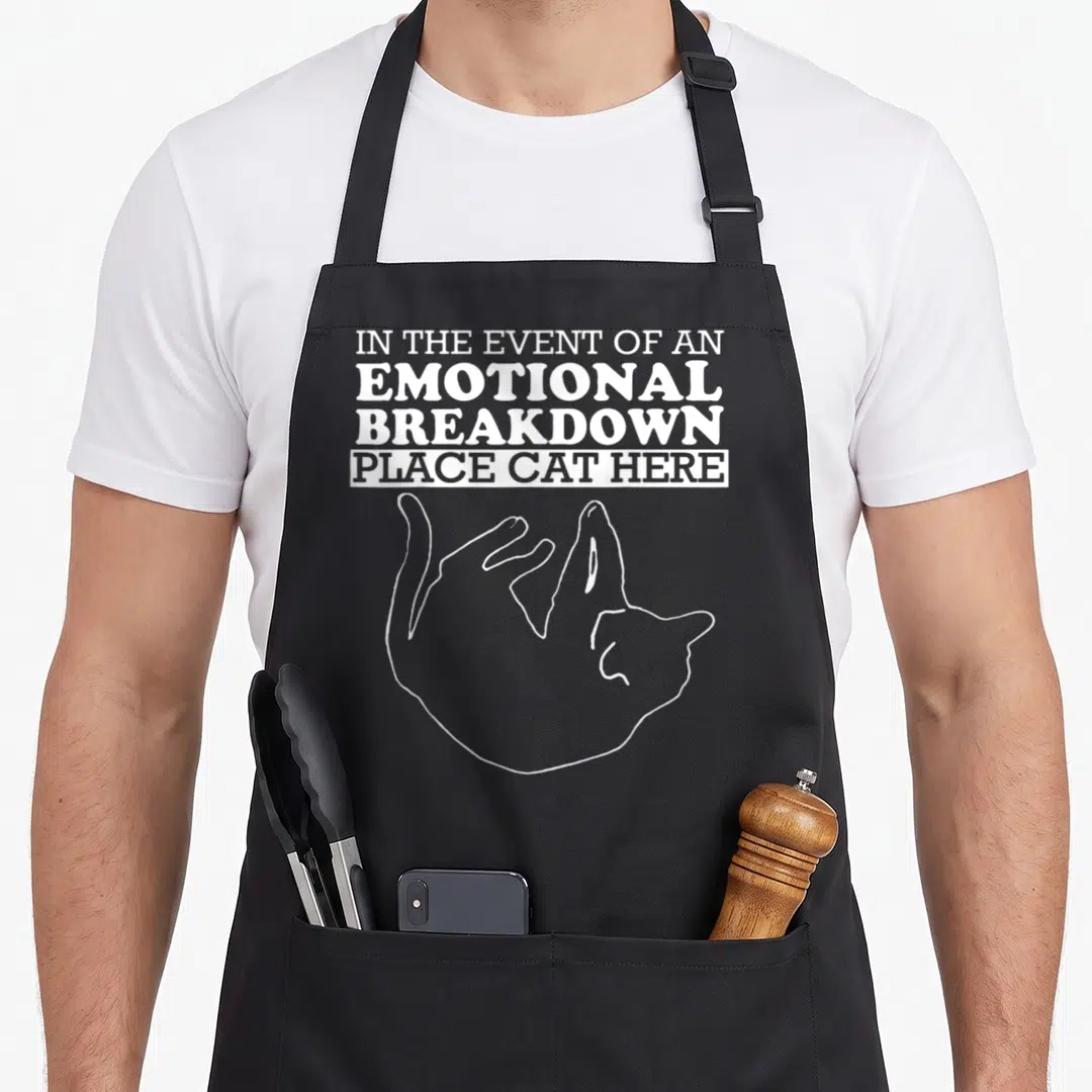 Kitty apron - White text and curled cat outline on black bib apron — shown on a black cotton canvas apron against a white background