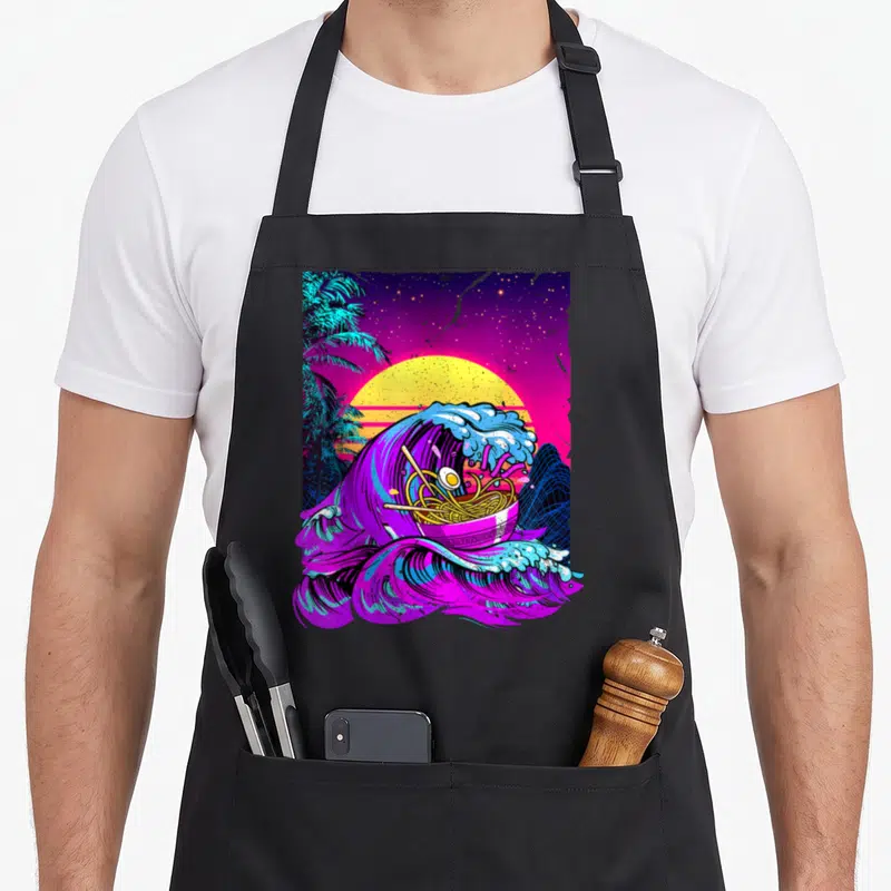 Wave anime apron - Retro vaporwave ramen bowl inside purple and blue wave with yellow sun and palm tree — shown on a black cotton canvas apron against a white background