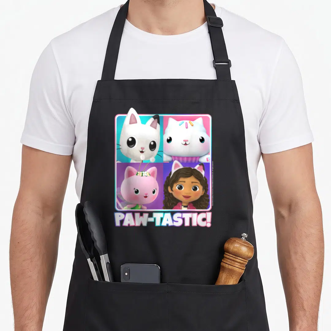 Gabby box apron - Four cartoon cat portraits in pink blue white purple grid with PAW-TASTIC! text below — shown on a black cotton canvas apron against a white background