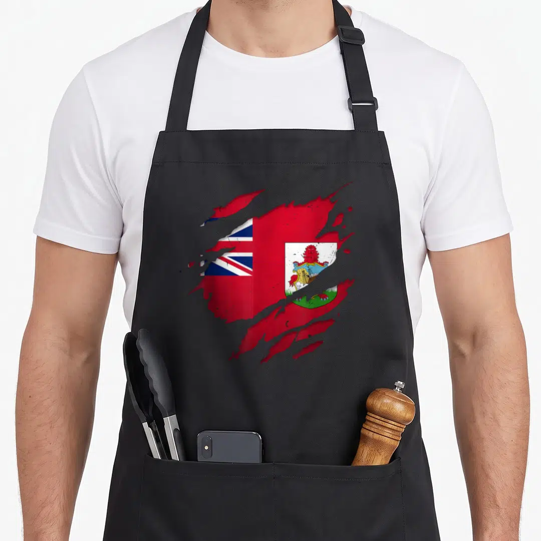 Bermuda torn apron - Realistic flag design with jagged red edges and blue white coat of arms on black background — shown on a black cotton canvas apron against a white background