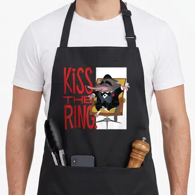 Kiss ring apron - Cartoon rat in a suit holding a diamond beside red KISS THE RING text — shown on a black cotton canvas apron against a white background