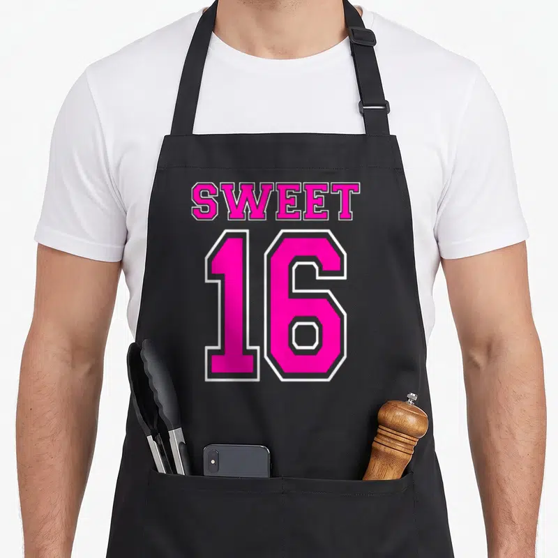 16th hot pink apron - Pink and white Sweet 16 varsity typography design with white outlines — shown on a black cotton canvas apron against a white background