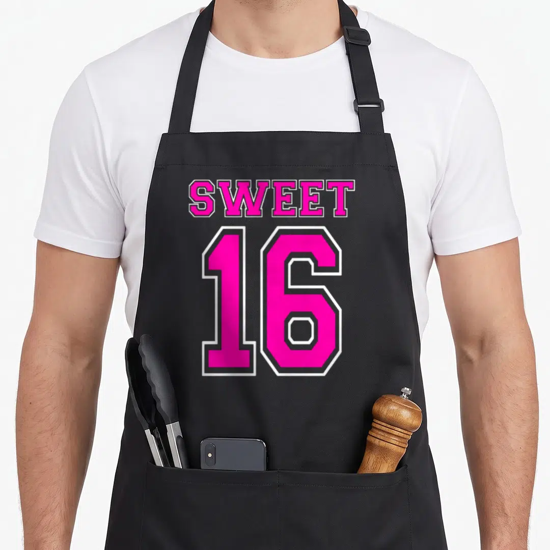 16th hot pink apron - Pink and white Sweet 16 varsity typography design with white outlines — shown on a black cotton canvas apron against a white background
