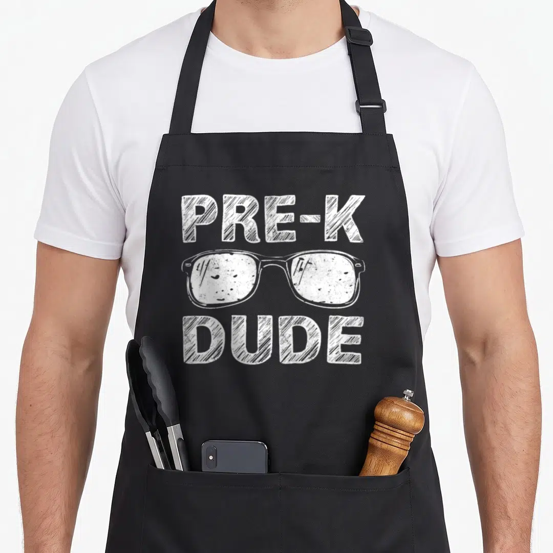 Pre dude apron - White distressed glasses with PRE-K above and DUDE below text — shown on a black cotton canvas apron against a white background