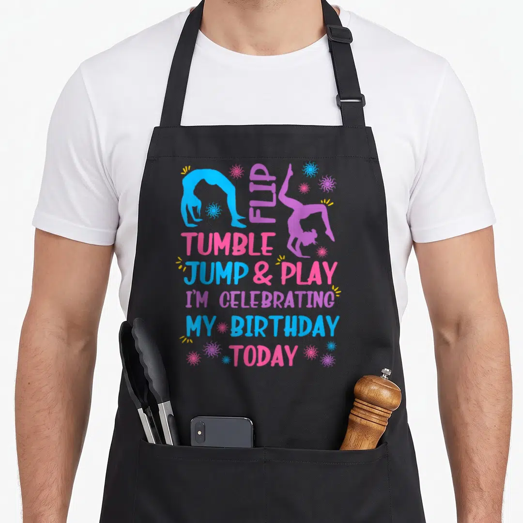 Themed birthday apron - Gymnast silhouettes and text Flip Tumble Jump Play I Celebrating My Birthday Today — shown on a black cotton canvas apron against a white background