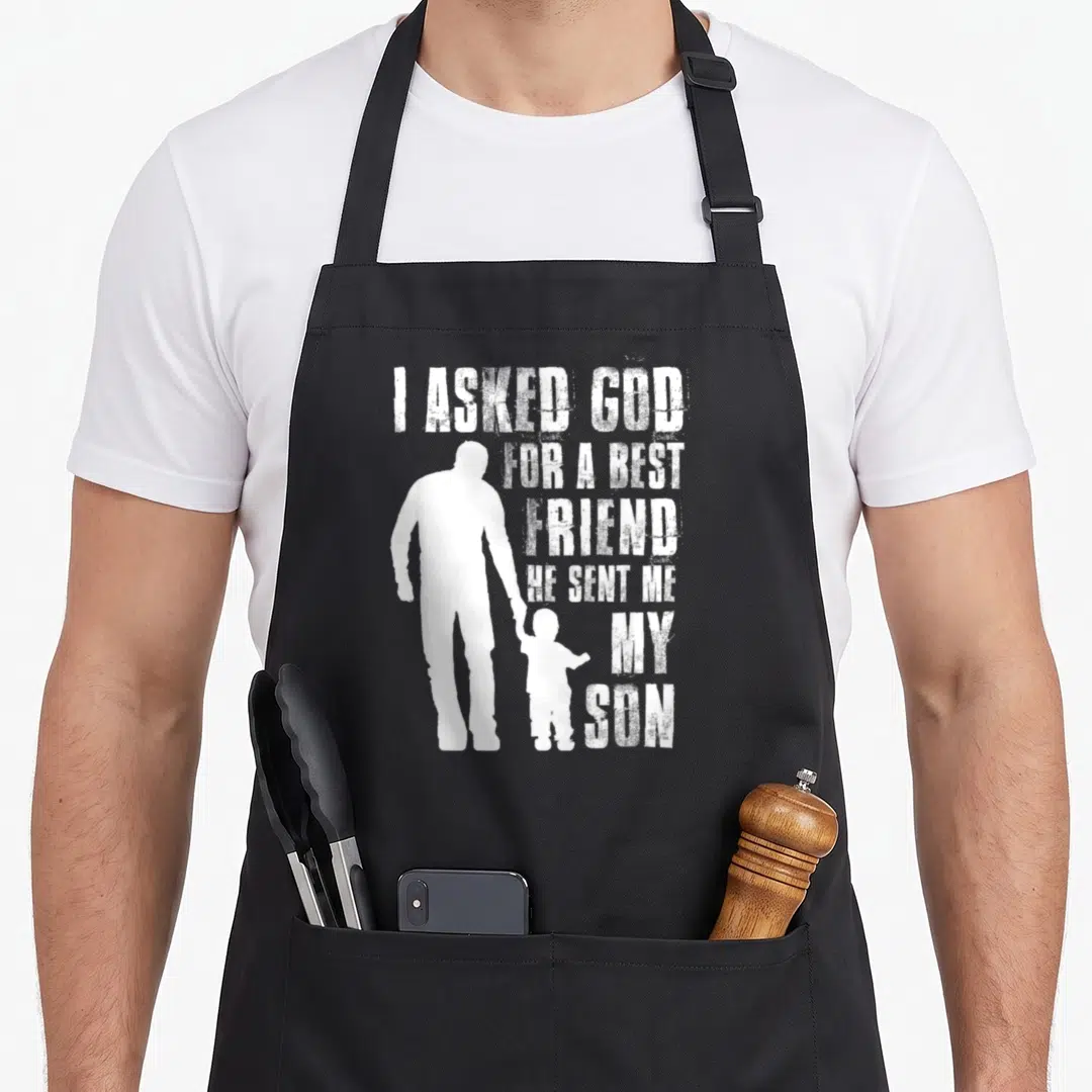 Asked father day apron - White I ASKED GOD FOR A BEST FRIEND text next to man and boy silhouettes holding hands — shown on a black cotton canvas apron against a white background