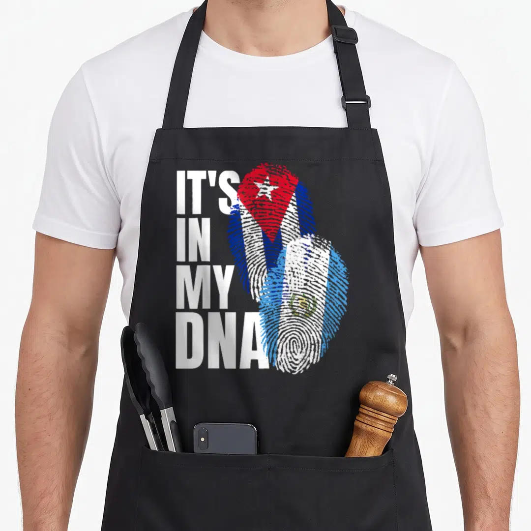 Cuban guatemalan aprons - Stacked IT'S IN MY DNA text next to overlapping Cuban and Guatemalan fingerprint flags — shown on a black cotton canvas apron against a white background