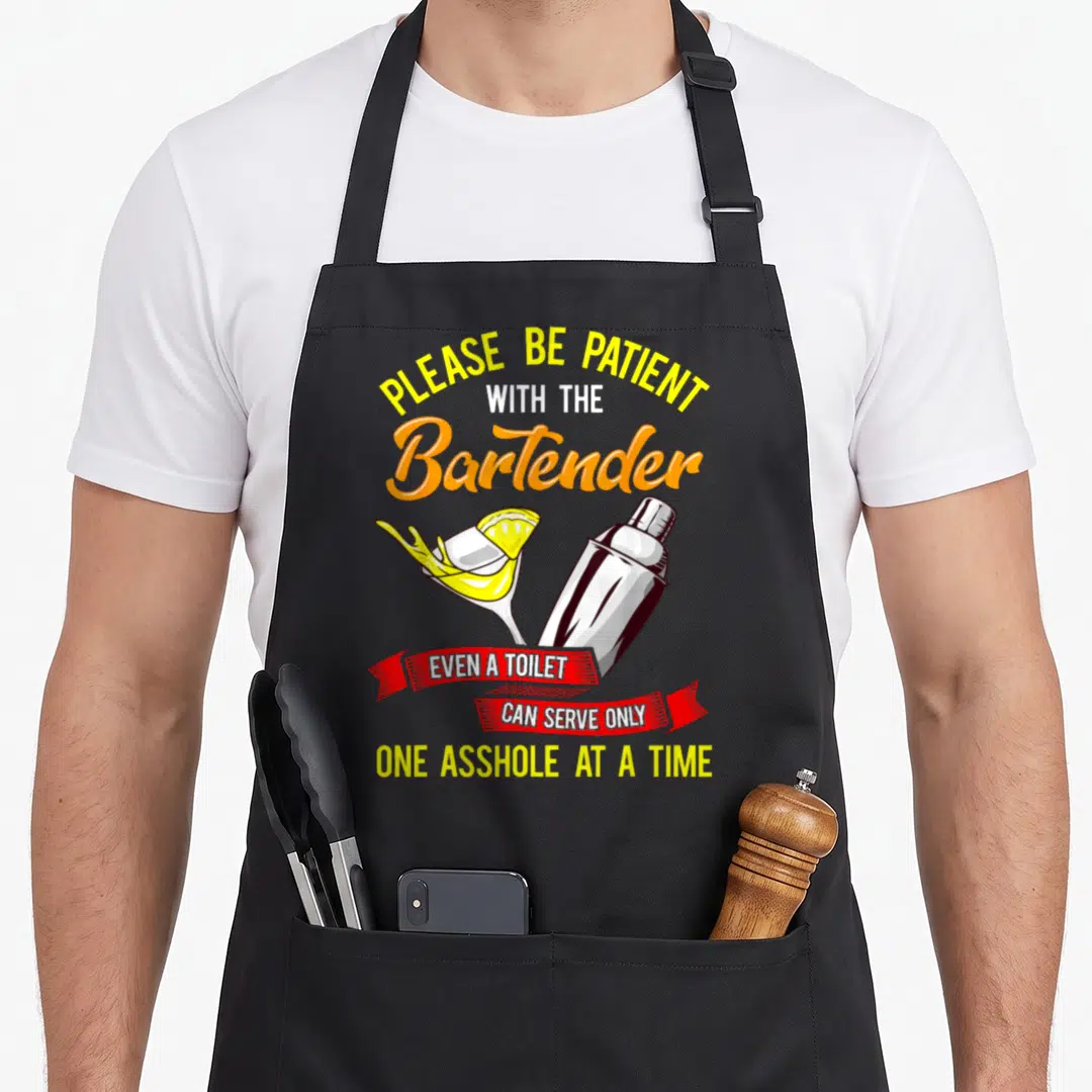 Bar owner bartender apron - Cartoon cocktail glass shaker with sarcastic yellow orange red white text on gray background — shown on a black cotton canvas apron against a white background
