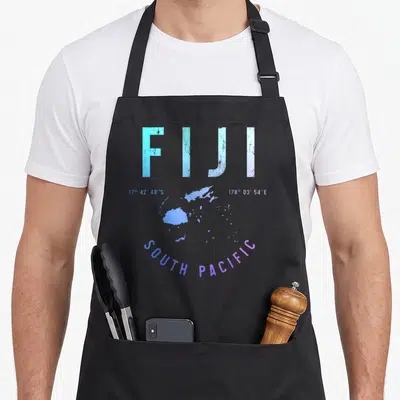 Souvenir fiji apron - Distressed FIJI map print with coordinates and SOUTH PACIFIC text in blue and purple — shown on a black cotton canvas apron against a white background
