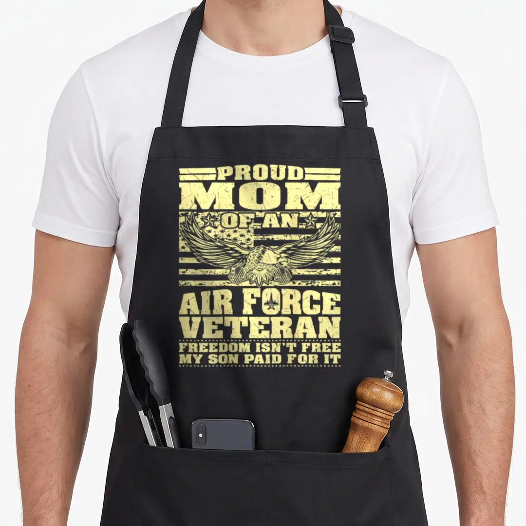 Veteran mom and son aprons - Yellow distressed text proud mom air force veteran eagle holding dog tags over flag stripes — shown on a black cotton canvas apron against a white background