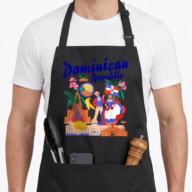 Republic fancy apron - Cartoon collage of Dominican Republic flag, traditional dancers, orchids, turtle, banana — shown on a black cotton canvas apron against a white background