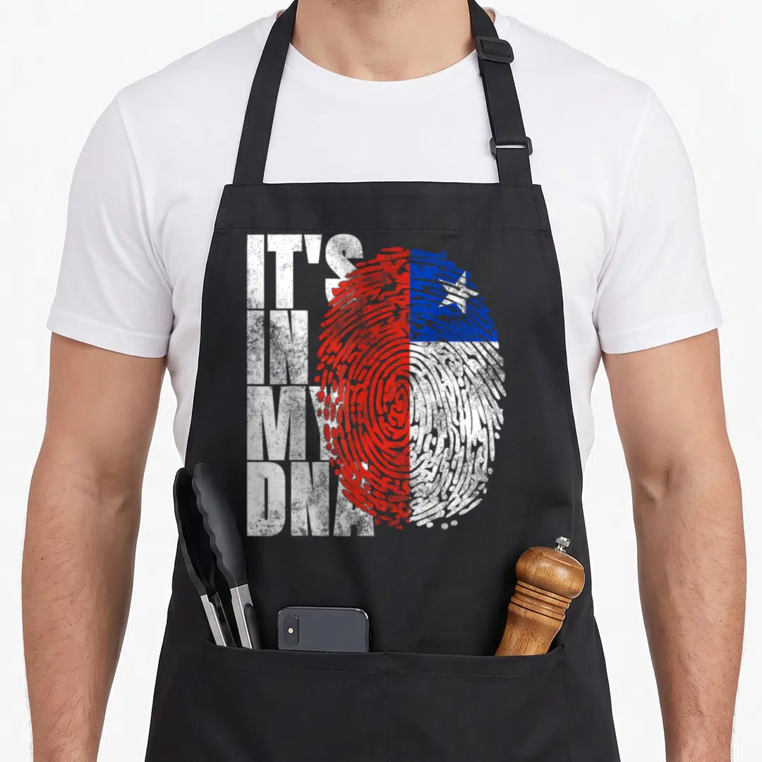 Chilean hispanic aprons - IT'S IN MY DNA text beside red white and blue fingerprint — shown on a black cotton canvas apron against a white background
