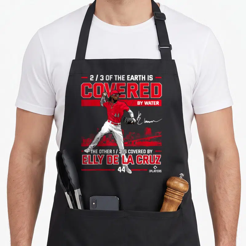 Covered las cruces apron - Elly De La Cruz baseball player with red skyline and 2/3 earth covered quote — shown on a black cotton canvas apron against a white background