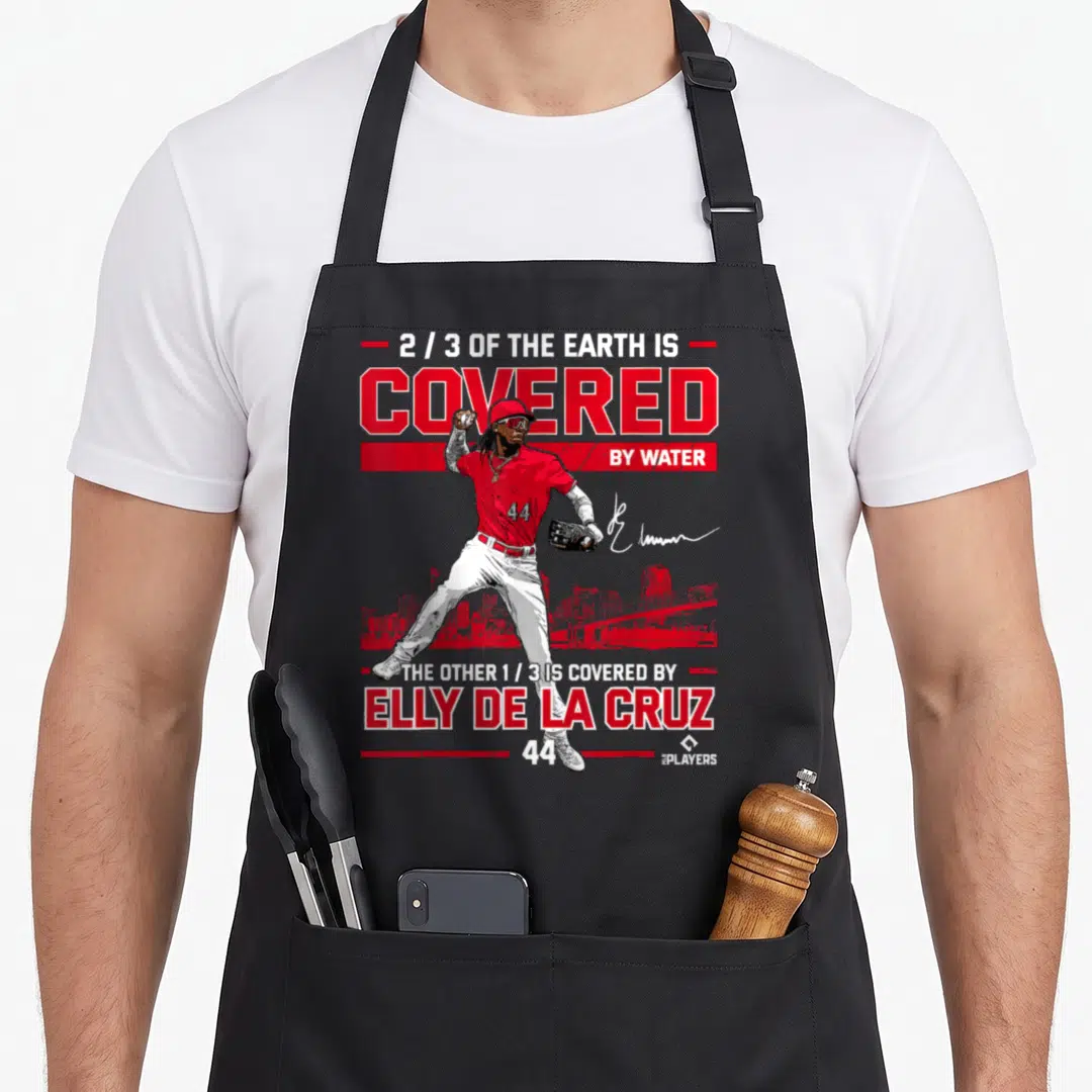 Covered las cruces apron - Elly De La Cruz baseball player with red skyline and 2/3 earth covered quote — shown on a black cotton canvas apron against a white background