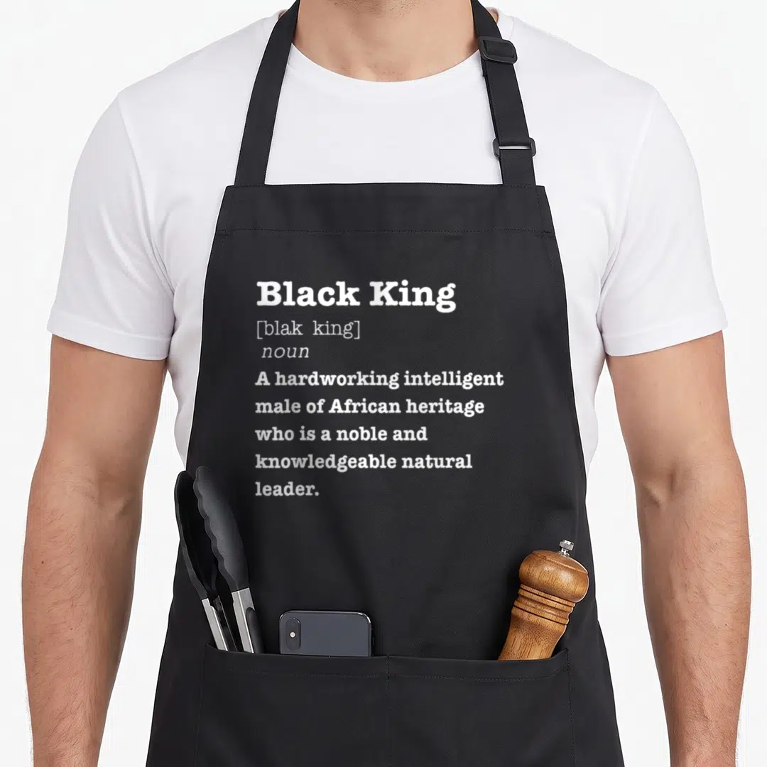 King african print apron - White stacked typography defining Black King as a noble African leader — shown on a black cotton canvas apron against a white background