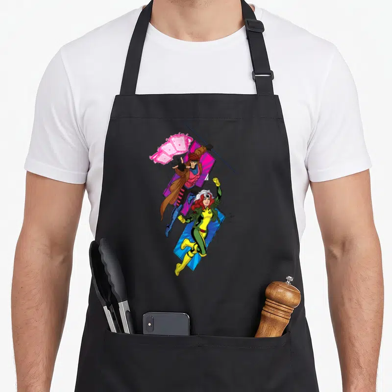 Studio super hero aprons - Two superheroes leaping diagonally with pink energy blast over blue and purple geometric — shown on a black cotton canvas apron against a white background