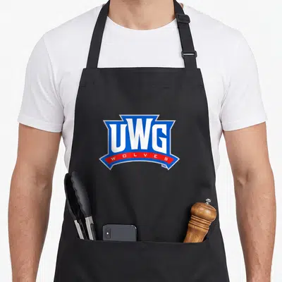 University wolves apron - UWG WOLVES shield logo in blue white and red typography — shown on a black cotton canvas apron against a white background