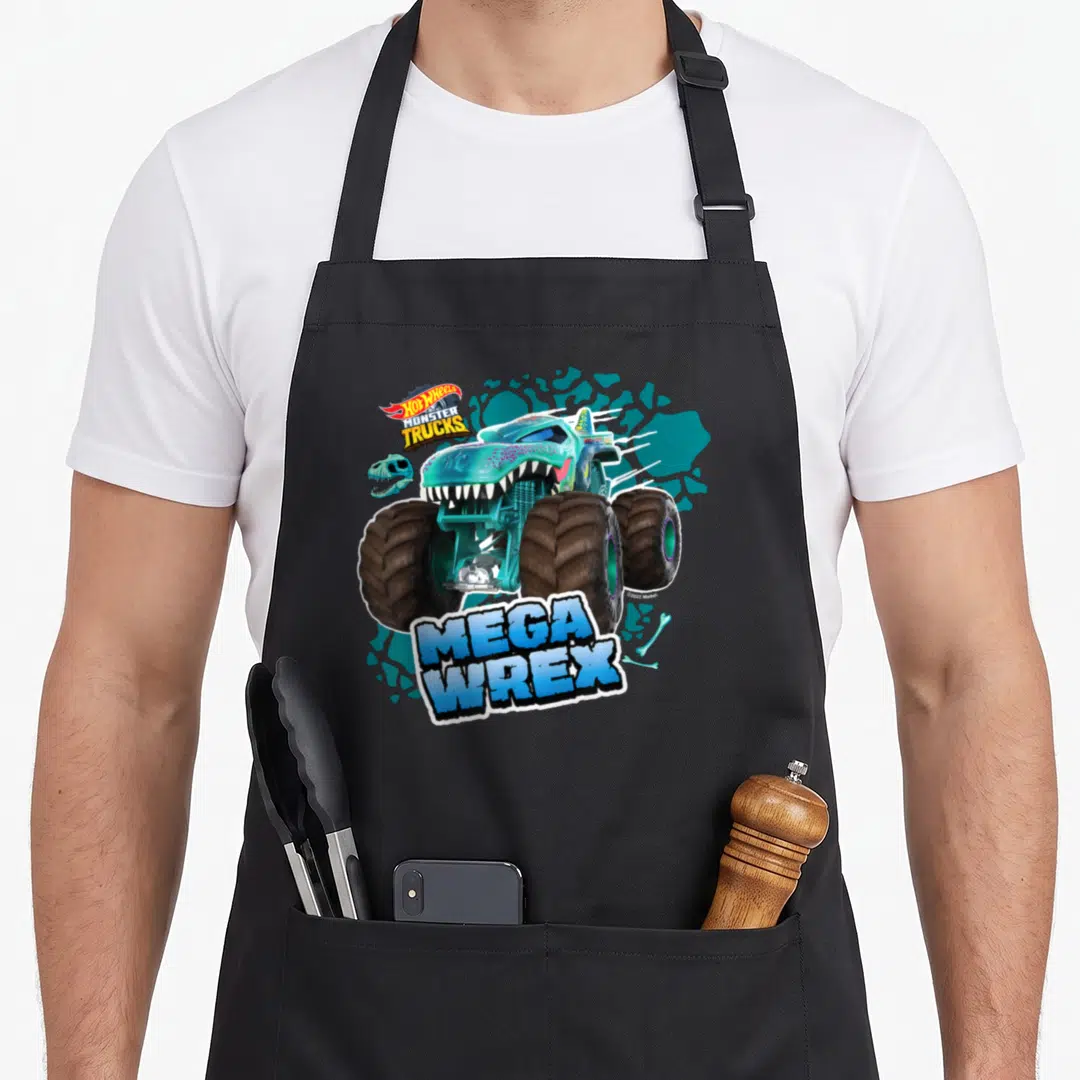 Mega wheel apron - Teal monster truck with dinosaur skull bones and MEGA WREX banner text on splatter background — shown on a black cotton canvas apron against a white background