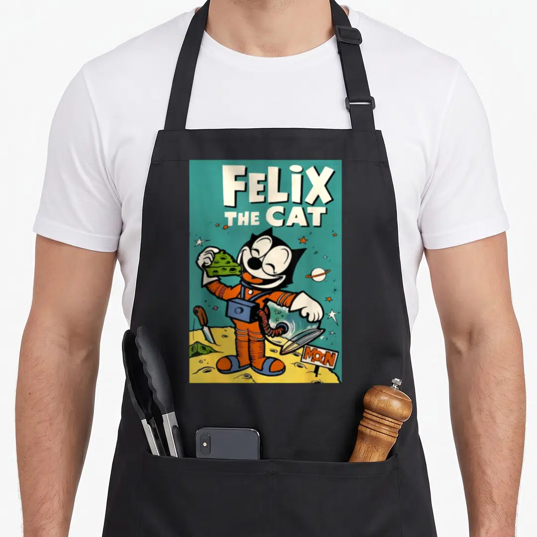 Moon 1920s apron - Felix the Cat in orange suit on yellow moon holding green cheese with teal background — shown on a black cotton canvas apron against a white background