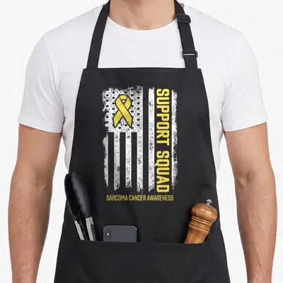 Cancer sarcoma awareness apron - Distressed white flag with yellow ribbon and vertical Support Squad text — shown on a black cotton canvas apron against a white background