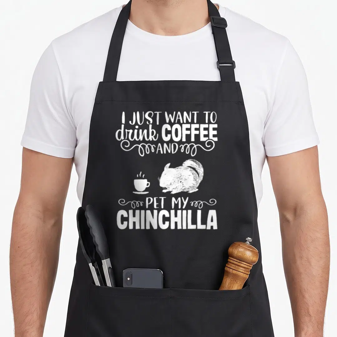 Chinchilla coffee apron - Distressed white text reading I just want to drink coffee and pet my chinchilla above — shown on a black cotton canvas apron against a white background