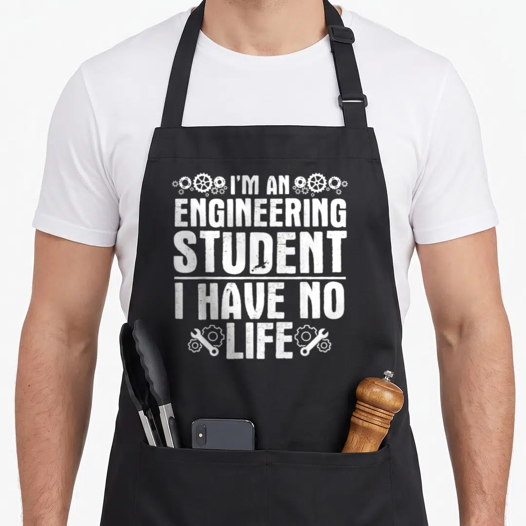 Funny engineer engineering apron - White distressed text I'M AN ENGINEERING STUDENT I HAVE NO LIFE with gears — shown on a black cotton canvas apron against a white background
