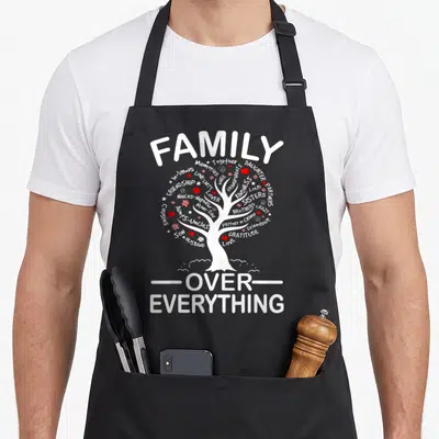 Family reunion aprons for dad - FAMILY OVER EVERYTHING tree design with kinship words and red hearts — shown on a black cotton canvas apron against a white background