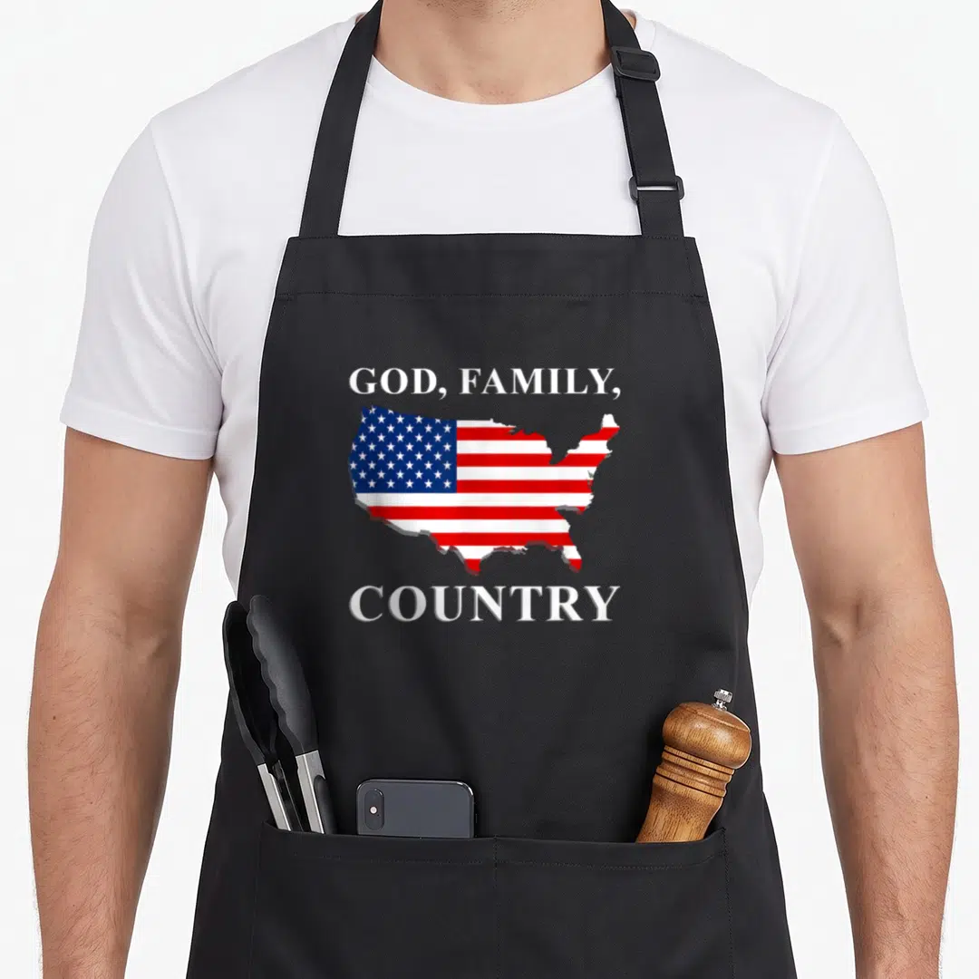 Jesus country apron - USA map filled with red white blue flag pattern under text God Family Country — shown on a black cotton canvas apron against a white background