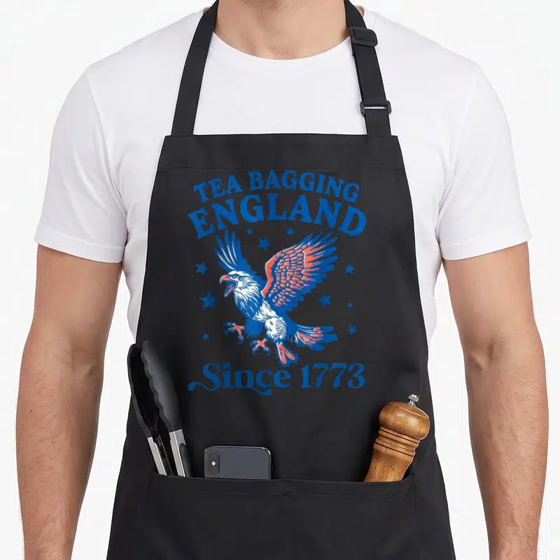 Bagging tea apron - Retro eagle surrounded by stars with TEA BAGGING ENGLAND and Since 1773 text in blue white and red — shown on a black cotton canvas apron against a white background