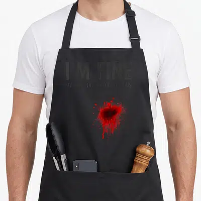 Fine essential apron - Grey apron with I'M FINE text and red blood-like splatter print — shown on a black cotton canvas apron against a white background