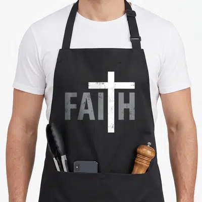 Christ cross apron - White cross forming the T in FAITH text on grey background — shown on a black cotton canvas apron against a white background