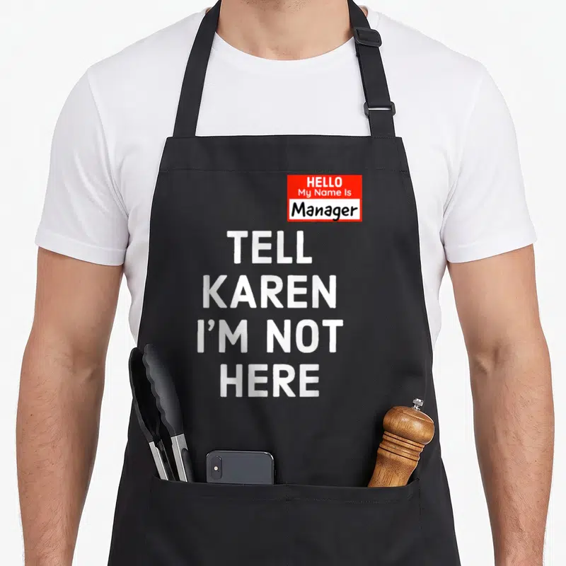 Minute halloween apron - Red name tag reading Manager with stacked white text TELL KAREN I'M NOT HERE — shown on a black cotton canvas apron against a white background