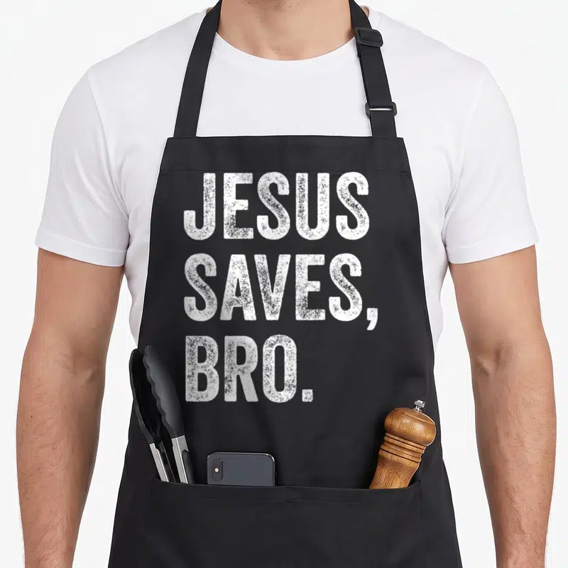 Jesus save bro christian apron - White stacked text reading JESUS SAVES, BRO on grey background — shown on a black cotton canvas apron against a white background