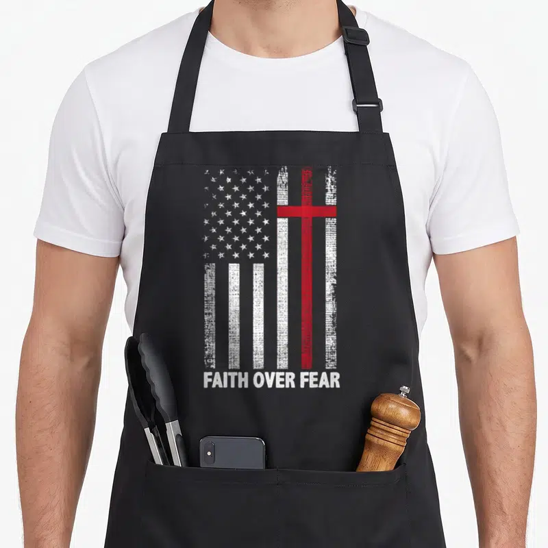 Cross american flag apron - Distressed US flag with red cross and FAITH OVER FEAR text — shown on a black cotton canvas apron against a white background